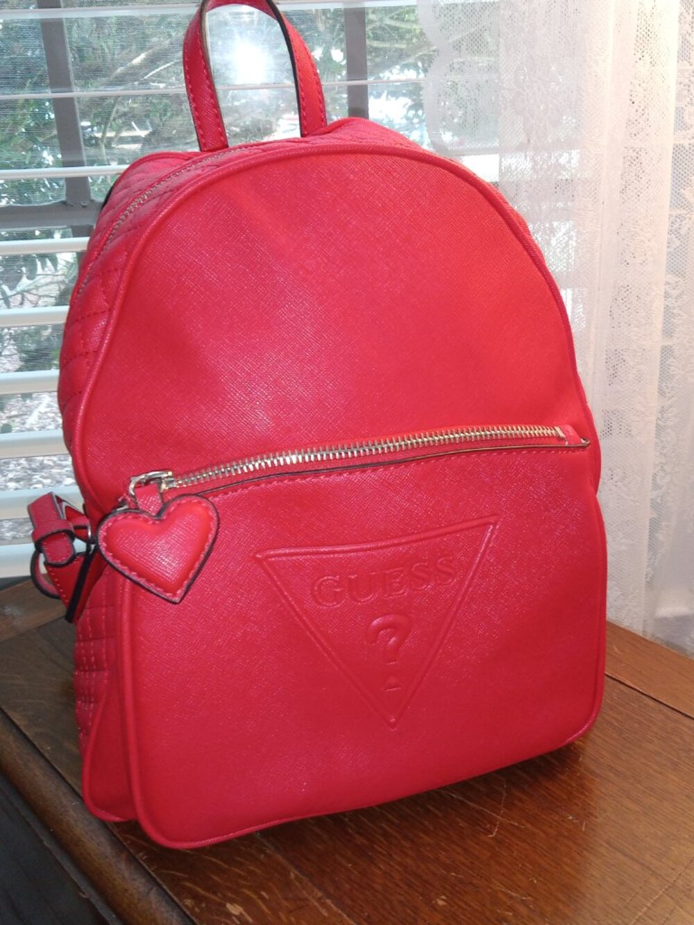 Red backpack purse with heart zipper by Guess brand